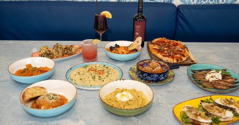 amurisandiego0028 Table set with arancini, pasta and cocktails showing what to order at a Sicilian restaurant in San Diego